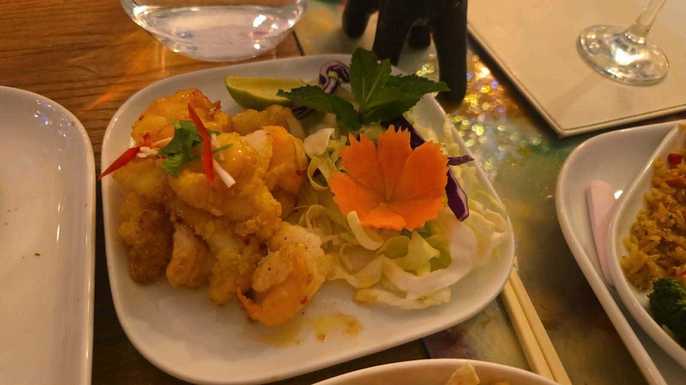 Crispy tempura prawns starter with carved carrot garnish