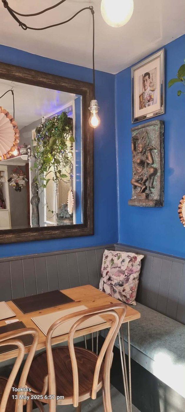 Tookta's dining area — blue walls, Thai apsara wall art and Edison bulb